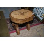 A lightwood Footstool with the emblem of The Parachute Regiment carved into the top,