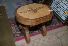 A lightwood Footstool with the emblem of The Parachute Regiment carved into the top,