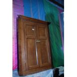 A medium Oak wall hanging Corner Cupboard having a pair of two panelled doors,