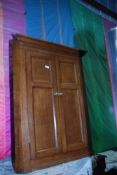 A medium Oak wall hanging Corner Cupboard having a pair of two panelled doors,