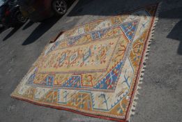 A large cream, blue and orange geometric, bordered, patterned and fringed Carpet, 80'' x 116''.