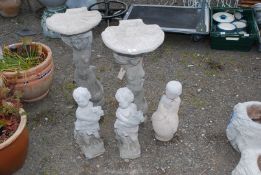 Two mermaid bird baths and three other concrete figures.