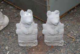 A pair of concrete Welcome dogs.