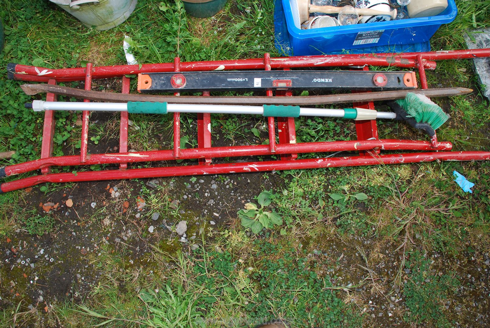 A metal step ladder, crow bar, car brush and level.