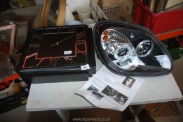 A Mercedes Benz SLK black projector halo Headlight R170, as new, offside and a battery wall clock.