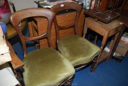 A pair of spoonback dining chairs with green velvet seats