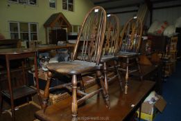 A darkwood refectory style table 60" x 26" x 30" high and 3 spindle back chairs.