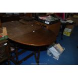 A dark wood oval drop leaf gateleg table