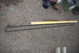 Two metal curtain poles, spirit level and bar.