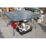 A glass topped patio table with recess for umbrella, 55'' x 35'' x 27'' high.