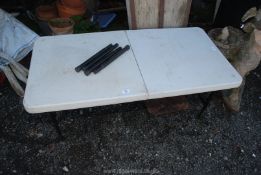 A fold up plastic table with metal extending legs.