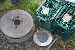 Two green Bulmer's bottle crates, roll of armour cable and extension reel.