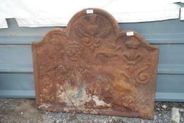 A cast iron fire back with a lion, rose, thistle and fleur de lis decoration.