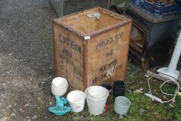 An old tea chest with various sized plastic pots and china pots.