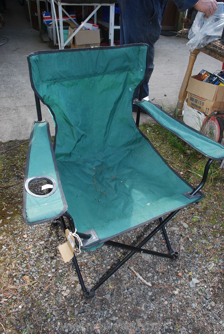 A collapsible canvas fishing chair in green.