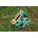 A large hose and reel and a water sprinkler.