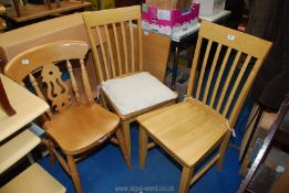 A lightwood square breakfast table with 2 chairs and a kitchen chair.