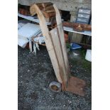 A vintage wooden sack truck on solid tyres.