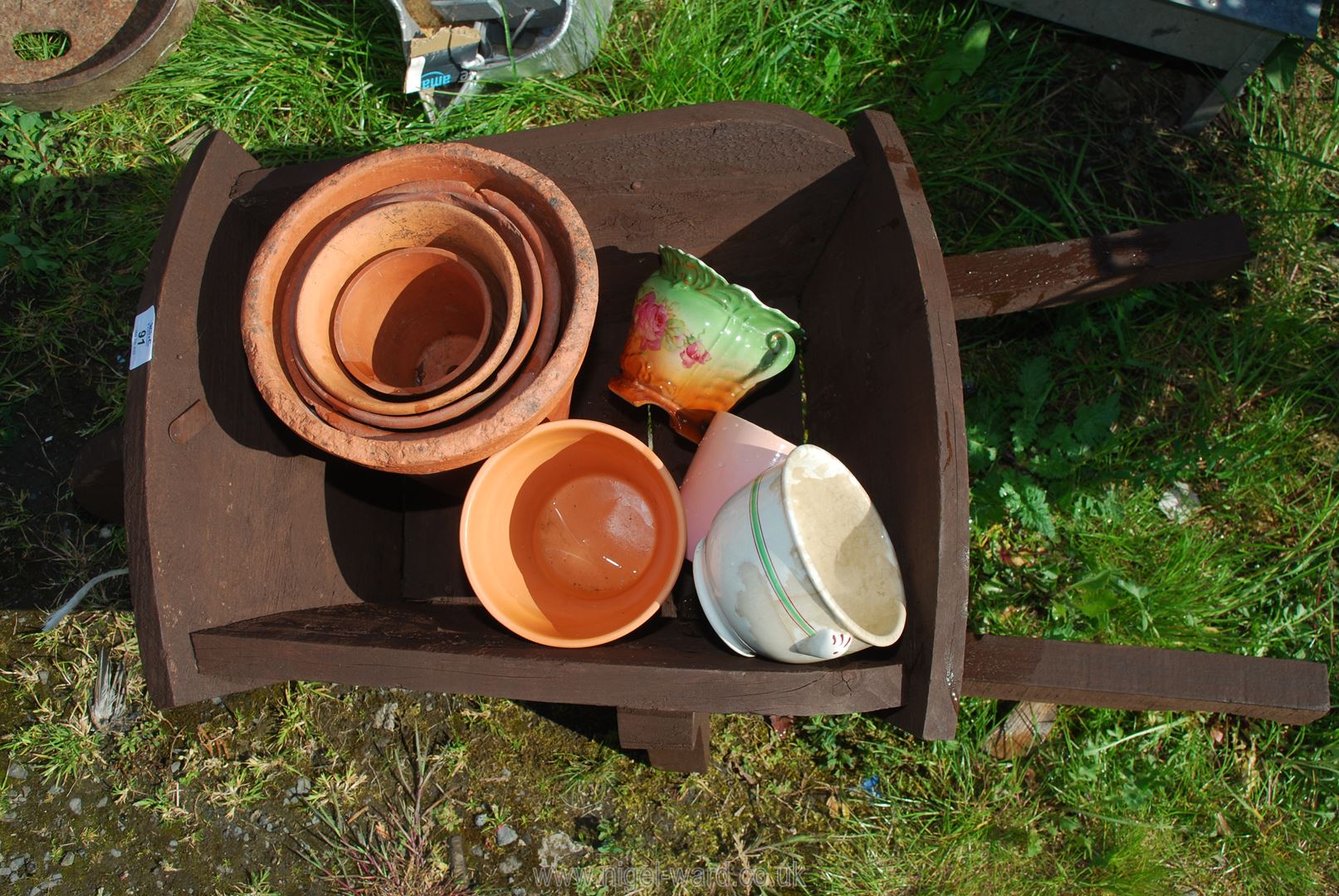 A small wooden wheelbarrow containing terracotta pots. - Image 2 of 2