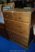 A stained pine chest of 5 long drawers over 2 short, 31" wide x 17 1/2" x 45" high.