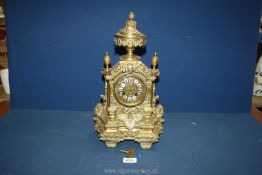 An ornate brass Mantle clock in Baroque style having swags and pillars and urn finial to the top,