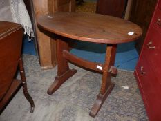 An Arts and Crafts type oval Oak occasional Table having a shaped pegged stretcher,
