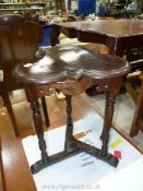 A dark Oak arts and crafts clover leaf topped occasional Table standing on turned,