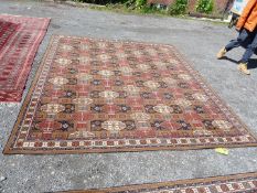 A large Wilton 'Ambala' rug patterned with lozenges in reds, blue and brown,