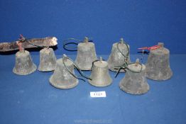 Eight cast bells, possibly service bells that had been mounted on a board.