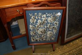 A Mahogany framed Firescreen having a framed tapestry of stylised foliage and flowers amongst a