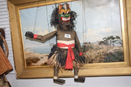 An ethnic/carved mask puppet having grass skirt, 18" tall.