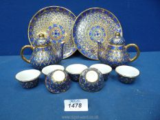 A pair of children's Teapots and seven tea bowls with hand painted decoration of blue, yellow,