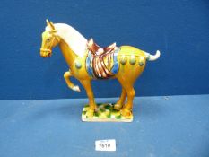 A reproduction Chinese Tang style horse in vibrant yellow, blue and green colours,