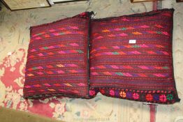 A pair of vintage handmade Afghan saddle bags, made up as cushions for conservatory or sofas,