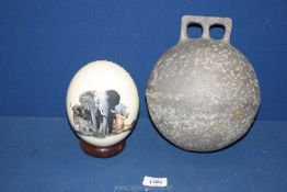 An aluminium fishing net float, approx. 9" tall and a decorated Ostrich egg and stand, 7" tall.