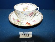 A large Dresden cup and saucer painted with flowers, early 20th c., some chips to cup.