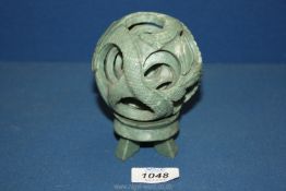 A jade puzzle ball carving and stand, 5" tall including stand.