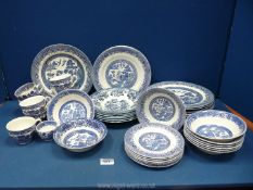 A quantity of blue and white Willow pattern china including plates, cups, bowls, soup bowls etc.