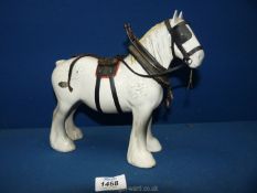 A dapple grey Beswick Shire horse having saddle, bridle and other attachments glued to figure.