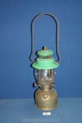 A brass 'Coleman' paraffin lamp having green enamel top, 13'' tall.