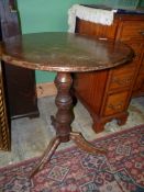A circular Oak occasional Table standing on turned pillar with three splay feet,