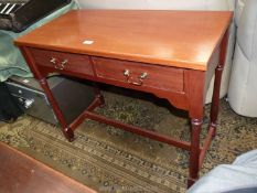 A light Mahogany contemporary side/writing Table standing on turned legs united by an 'H' stretcher