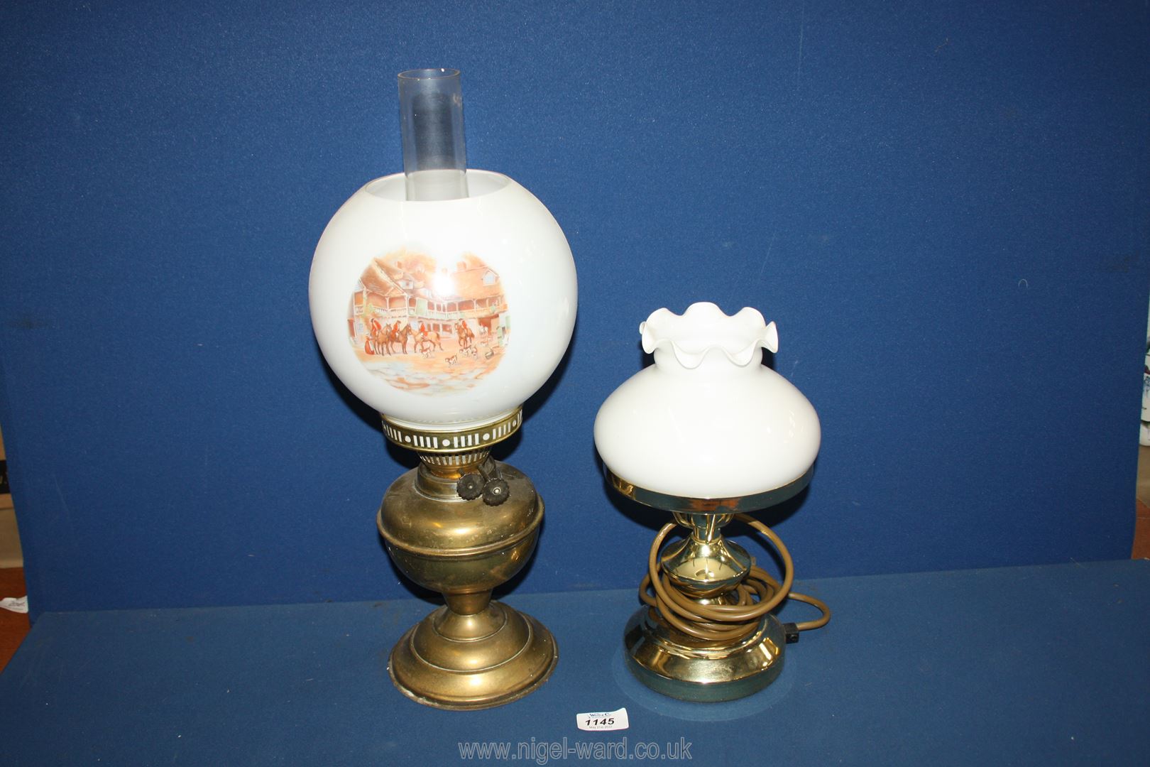 An Oil Lamp with brass base, white glass shade decorated with hunting scenes and clear chimney,