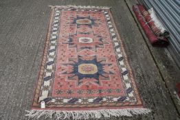 A faded red and blue,cream and yellow Runner rug having border pattern and fringing 81" x 40".