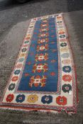 A long wool Runner rug having geometric and flower border pattern, central blue panel,