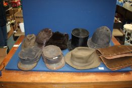 A box of hats including two Railway caps, Policeman's helmet, green felt hat (6 7/8),