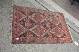 A small hand woven eastern Rug with geometric pattern, red, orange and black ground, 34" x 56".