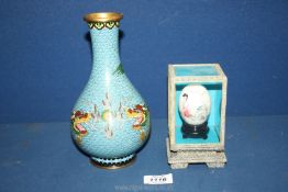 A modern cloisonne Dragon bottle vase together with a Japanese egg with stand in glass display case.