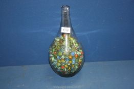 A glass bottle containing Marbles