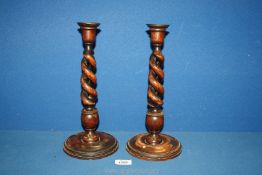 A pair of treen candlesticks with double helix stem, 12 1/2'' tall, one a/f.